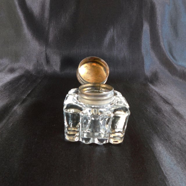 This is a glass inkwell that almost looks poured-except it has no seams. It has a metal attached lid that has no markings....