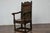 An English Jacobean oak high back armchair from the late 17th century with carved décor. This English Jacobean period oak...