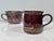 These two handcrafted ceramic mugs, one a large cocoa cup and the other a large coffee mug, bear the distinctive style of...