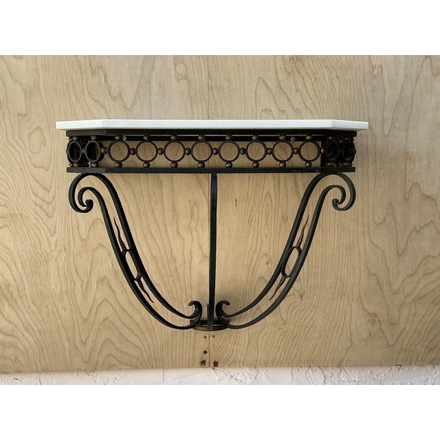 This elegant vintage scrolled iron wall console is crafted in the style of Jean Royère, capturing the sculptural...