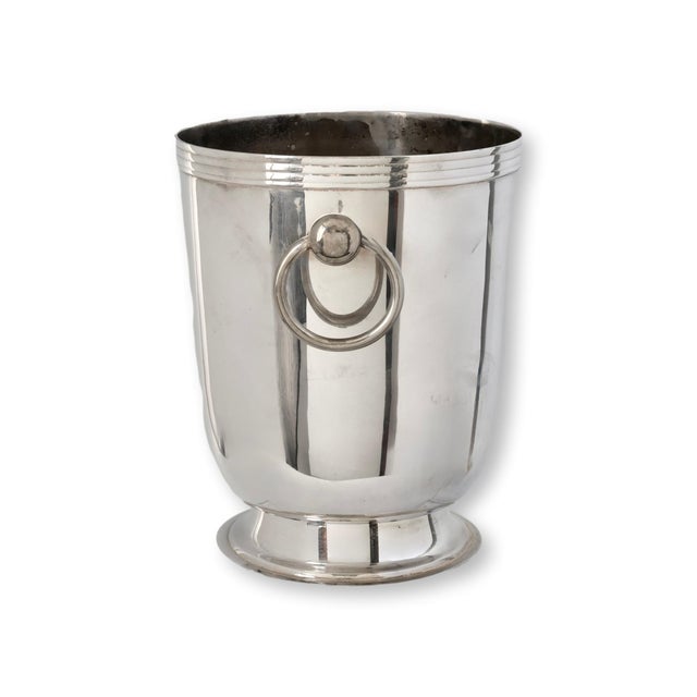This elegant French silverplate champagne bucket features a classic tapered form accented with simple ring handles and a...