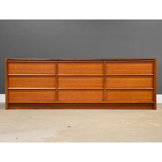 A mid century modern teak nine drawer dresser made by New Furniture. Made in Denmark. Circa 1960’s. Professionally...