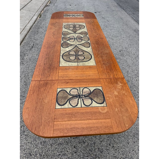 Mid century Danish dining table. The table features two drop fold leaves that can easily dangle down or be removed for...