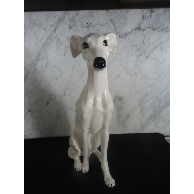 A whimsical porcelain figure of a sitting whippet circa 1971. Made in Italy