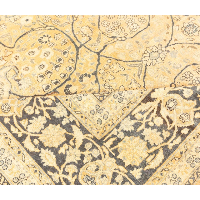 A late 19th century Mashad Persian rug, the dusty peach field with scattered fleurons under a trellis of whimsical...