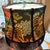 A richly patterned vintage lampshade featuring a bold tiger motif surrounded by vibrant florals, rendered in saturated...