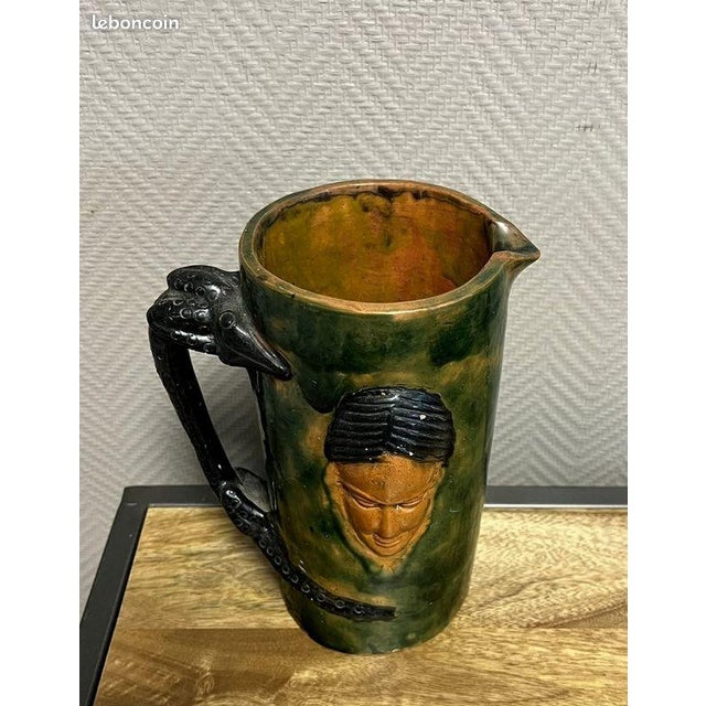 Large glazed terracotta pitcher with an Asian or Indian face and a salamander in relief A very beautiful piece Dimensions:...