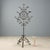 Wrought iron torch holder with seven flames. Tripod base and decoration of scrolls, spikes, and stylized flowers in the...