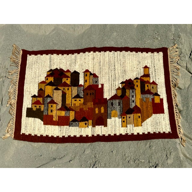 This Polish kilim by Boguslaw Kaminski depicts an intricately detailed landscape of houses, combining traditional weaving...