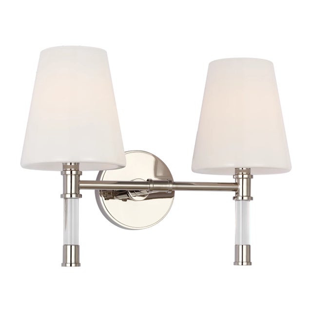 Slender curved, tapered arms form an elegant, dynamic silhouette . In the Hanover two-light wall vanity, lucite arms form...