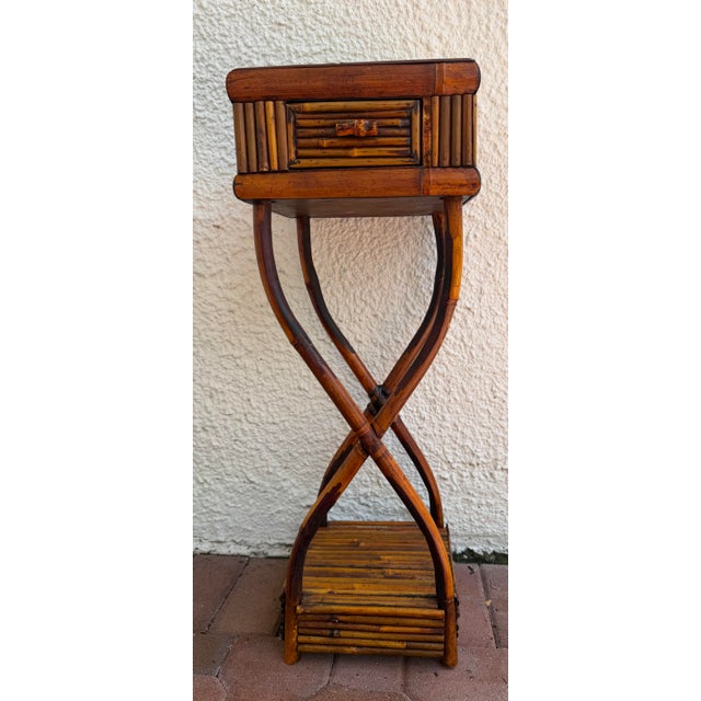 This vintage burnt bamboo sculptural side table features a intricate reeded pattern top and a single drawer.
