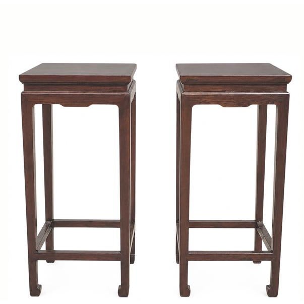 This pair of elegant Asian accent tables is handmade of solid elm. With four elegantly shaped legs ending in stylized...