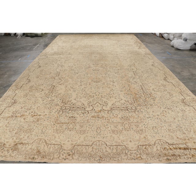 Hand knotted in wool circa 1930-40, this oversized 11x21 antique Kerman Lavar rug is an especially rare and exciting new...