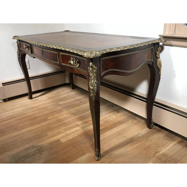 A terrific French Louis XV style kingwood bureau plat or writing desk with a leather top, bronze mounts and dovetail...