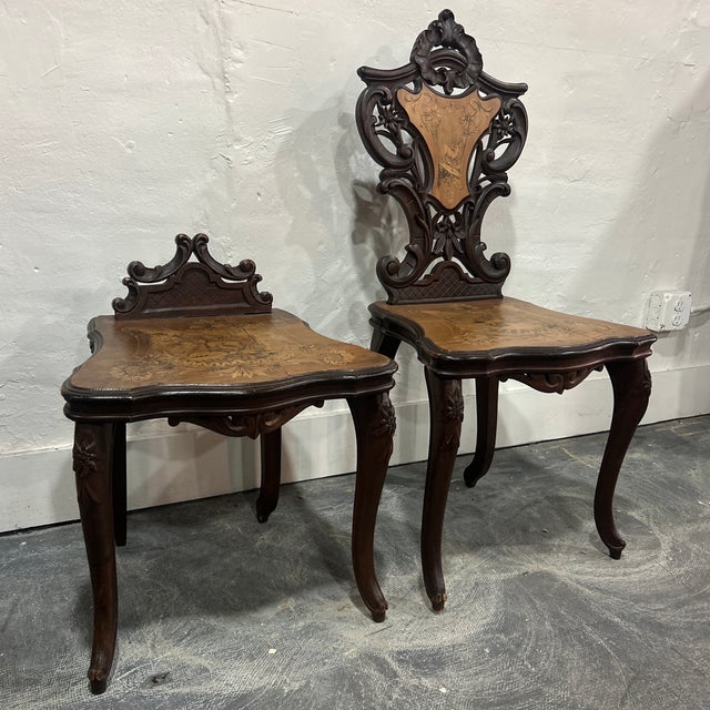 Beautiful Black forest style Swiss chairs. One female chair for gowns. Inlaid ram design on the seats