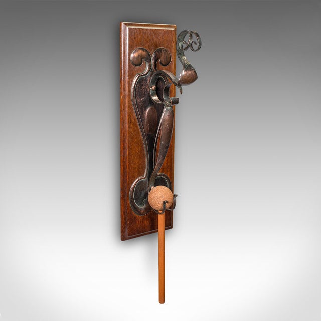 This is an antique wall gong. An English, oak and bronze dinner chime in Art Nouveau taste, dating to the late Victorian...