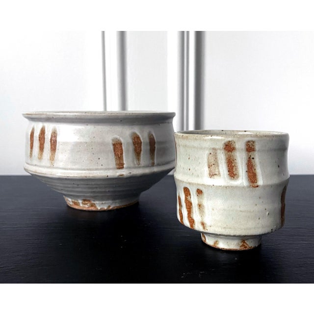 A stoneware tea bowl by American ceramist Warren Mackenzie (1924-2018). Potted in a column shape with a prominent...