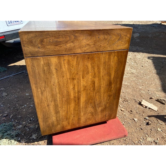 This Vintage Mid Century Modern Drexel Campaign Desk from 1984 features a brown lacquered finish with a unique brass...