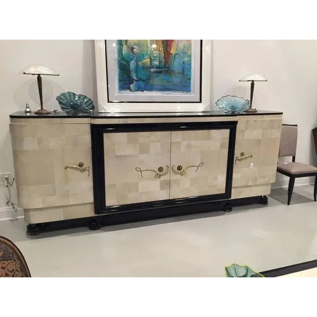 French Art Deco spectacular parchment buffet with ebony marble top and "Portor" legs. With gold hardware that accents the...
