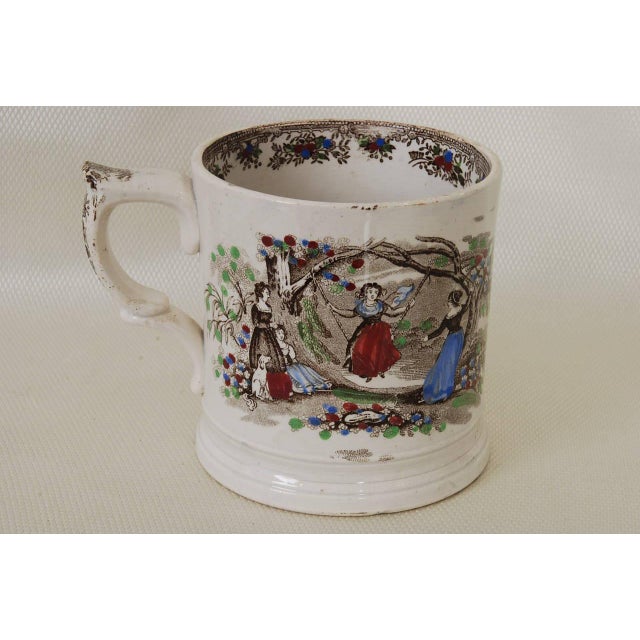 Staffordshire frog mug transfer printed in brown and over painted by hand. One side depicts fruit picking while the other...