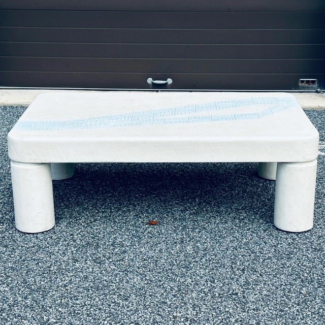 Plaster postmodern coffee table circa 1970 with column like round legs and rounded corners. Incised design on the top with...