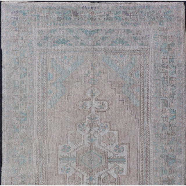 Measures: 4'7 x 8'4 This vintage beauty was hand-knotted in Turkey during the 1950's. Vintage Oushak rugs are incredibly...