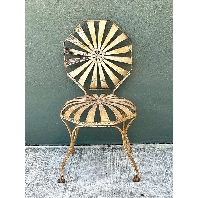 This vintage Francois Carre garden chair showcases the designer's iconic sunburst motif in a strikingly weathered state,...