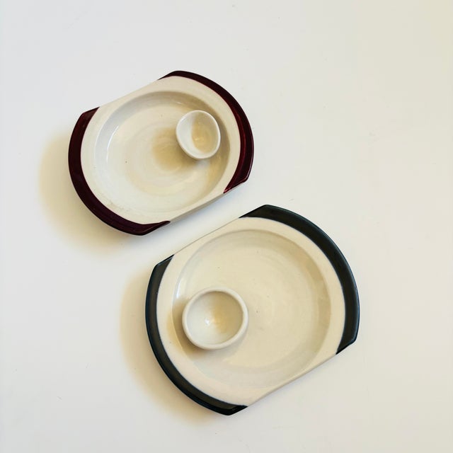 A set of 2 vintage studio pottery small serving plates. Each has a small bowl attached to the surface for sauces. One is...