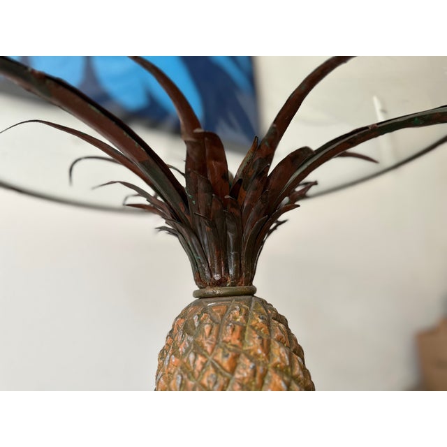 This striking pineapple-form coffee table is crafted from polychrome painted iron and features a circular inset glass top....