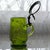 Charming late 19th-century German enameled glass syrup pitcher featuring a rich green glass body with hand-painted...