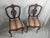 An elegant pair of French Louis XV style side chairs featuring hand-carved shell crests, pierced splat backs, and graceful...