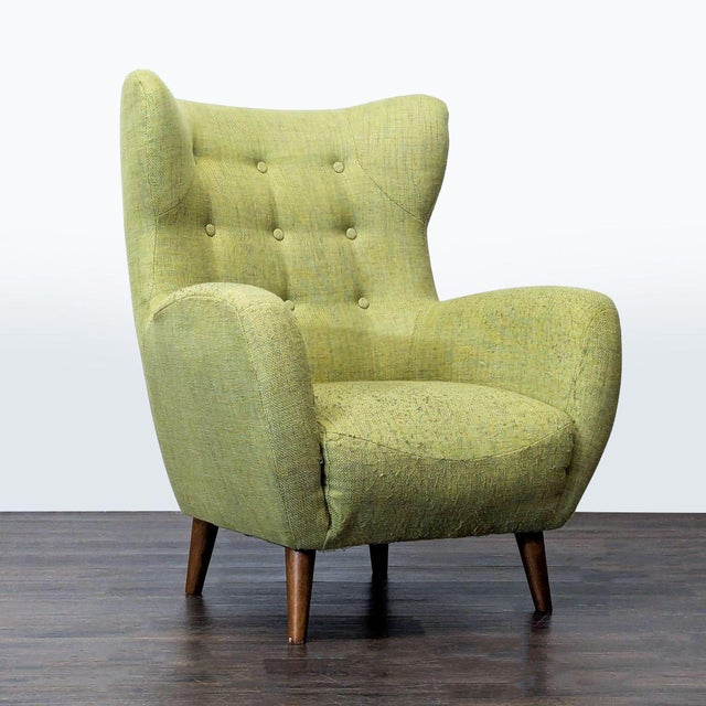 This stylish lounge chair from Article features a mid-century modern design with a soft green fabric and button-tufted...