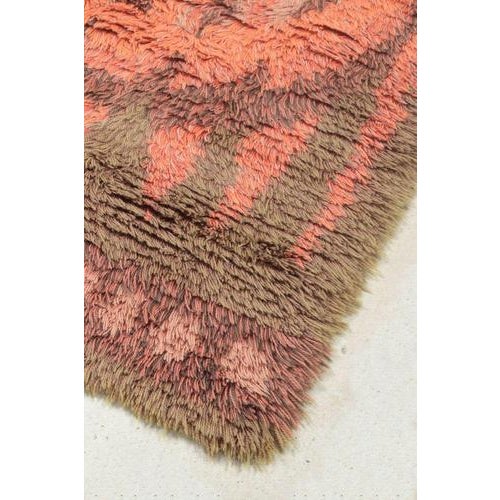 Scandinavian designer Rya carpet, 1960/70s. Hand-knotted rya rug in wool featuring a sun-inspired motif in warm shades of...