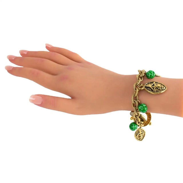 This rare Guy Laroche Paris tribal link bracelet features a dangling design with charms in African-inspired mask and...