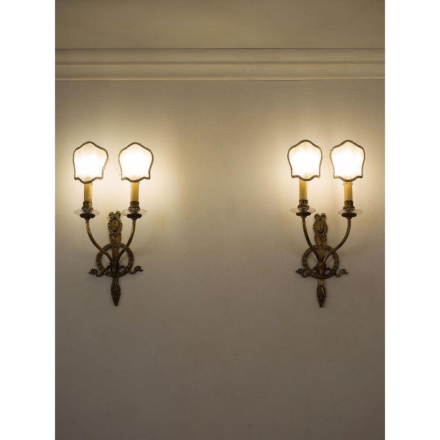 A pair of Italian two-light wall sconces in chiseled brass, made in the first half of the 20th century. The design...