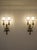 A pair of Italian two-light wall sconces in chiseled brass, made in the first half of the 20th century. The design...