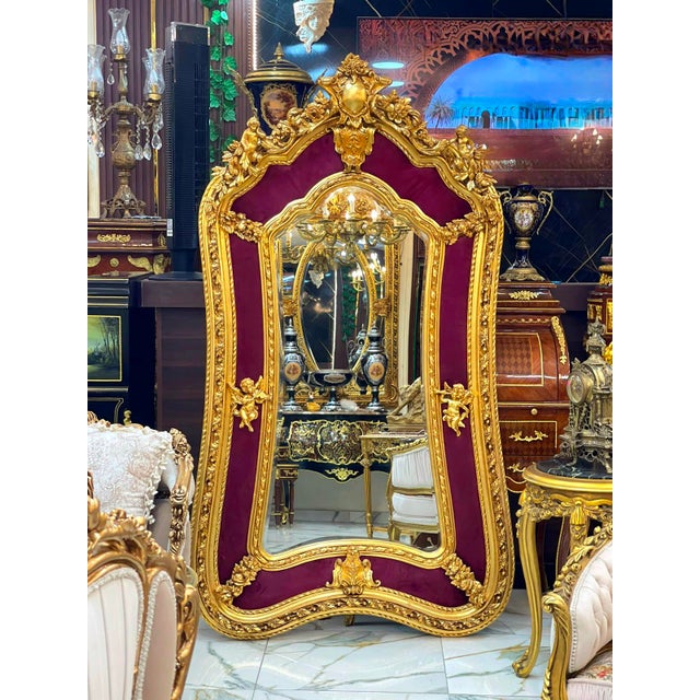 Make a dramatic statement with this grand French Rococo–style mirror, beautifully crafted with an elaborate gold leaf...