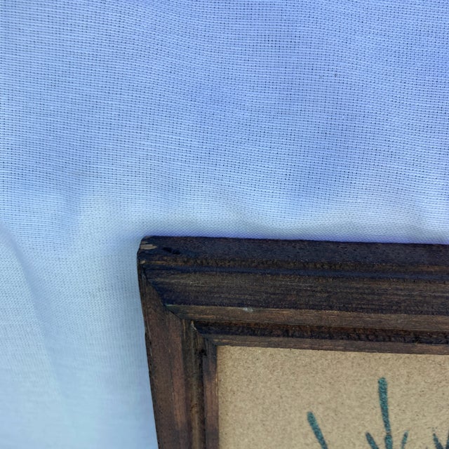 This Native American style sand art in frame measures 13.5”x13.5”. There is an artists signature .the frame has some nicks...