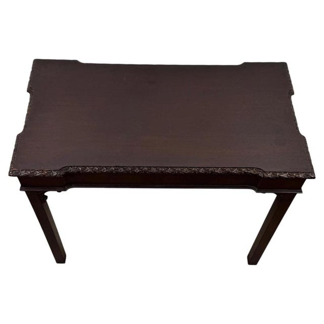 A handsome early 20th-century English side table in the Chippendale style, finely crafted from mahogany and distinguished...