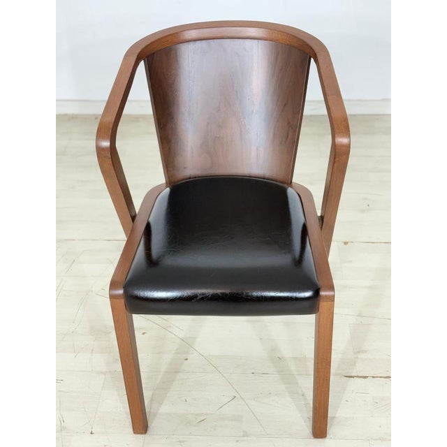 Armchair in a timeless retro design with a beautifully curved wooden backrest and a comfortable seat cushion upholstered...