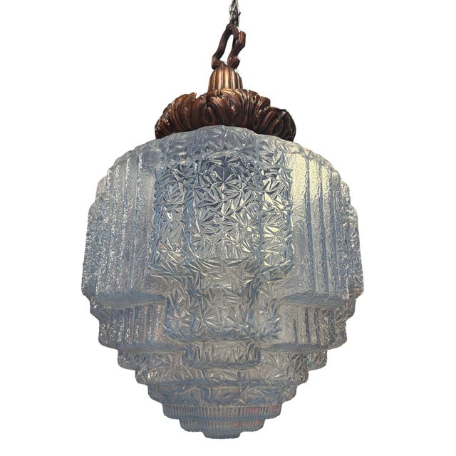 1930s Art Deco pendant light featuring a stepped and line-textured "Skyscraper" blue cobalt glass shade and ornate cast...