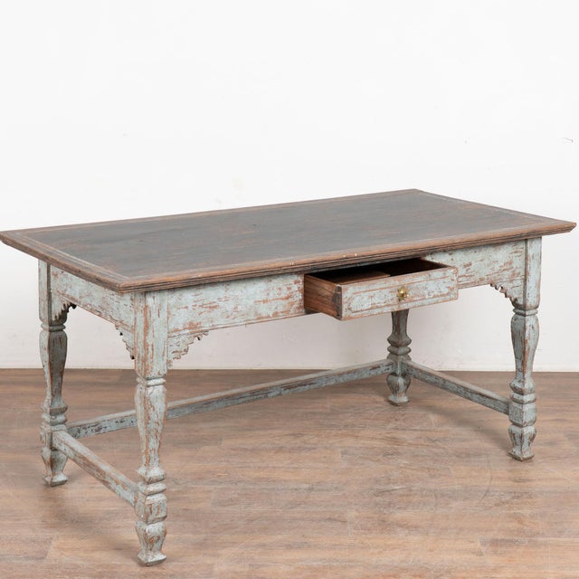 This handsome baroque library table with one drawer has handsome turned legs and traditional stretchers between the legs....