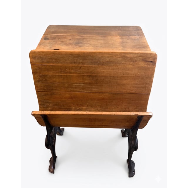 Antique school desk with wood seat and desk and embellished metal siding / chair legs.