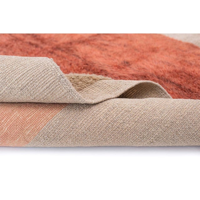 Three warm color blocks — terracotta, rust, and clay — float against a soft neutral beige ground, stacked like sunbaked...