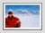 Haute Route Take Off by Toni Frissell A skier smiles from the top of a mountain in the clouds as a plane flies over head,...