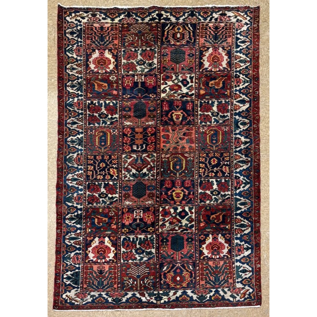 Hand-knotted rug from the Bakhtiari tribes of western Iran, featuring a classic Kheshti (garden panel) design composed of...