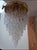 Exquisite cascading chandelier. Italy, 1970s. Brass base. Wavy Murano glass pendants suspended by brass chains. Given...
