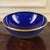 This vintage cobalt blue glass serving bowl features a gilded rim, adding a touch of elegance to any dining table or...