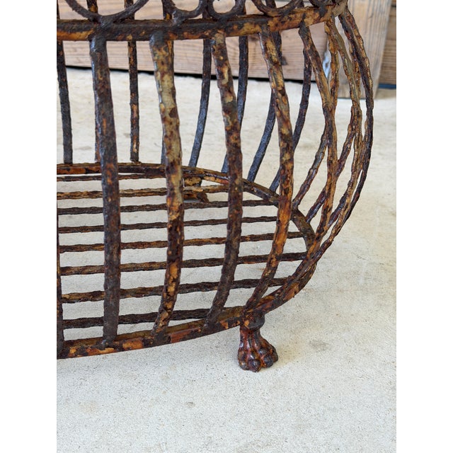 A wonderfully timeworn vintage iron jardinière featuring an elegant openwork design with scrolling details and distinctive...