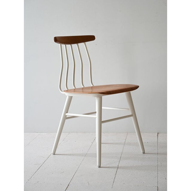 1960s Scandinavian chair with shaped wooden seat and white painted wooden structure. The distinctive aspect of this chair...